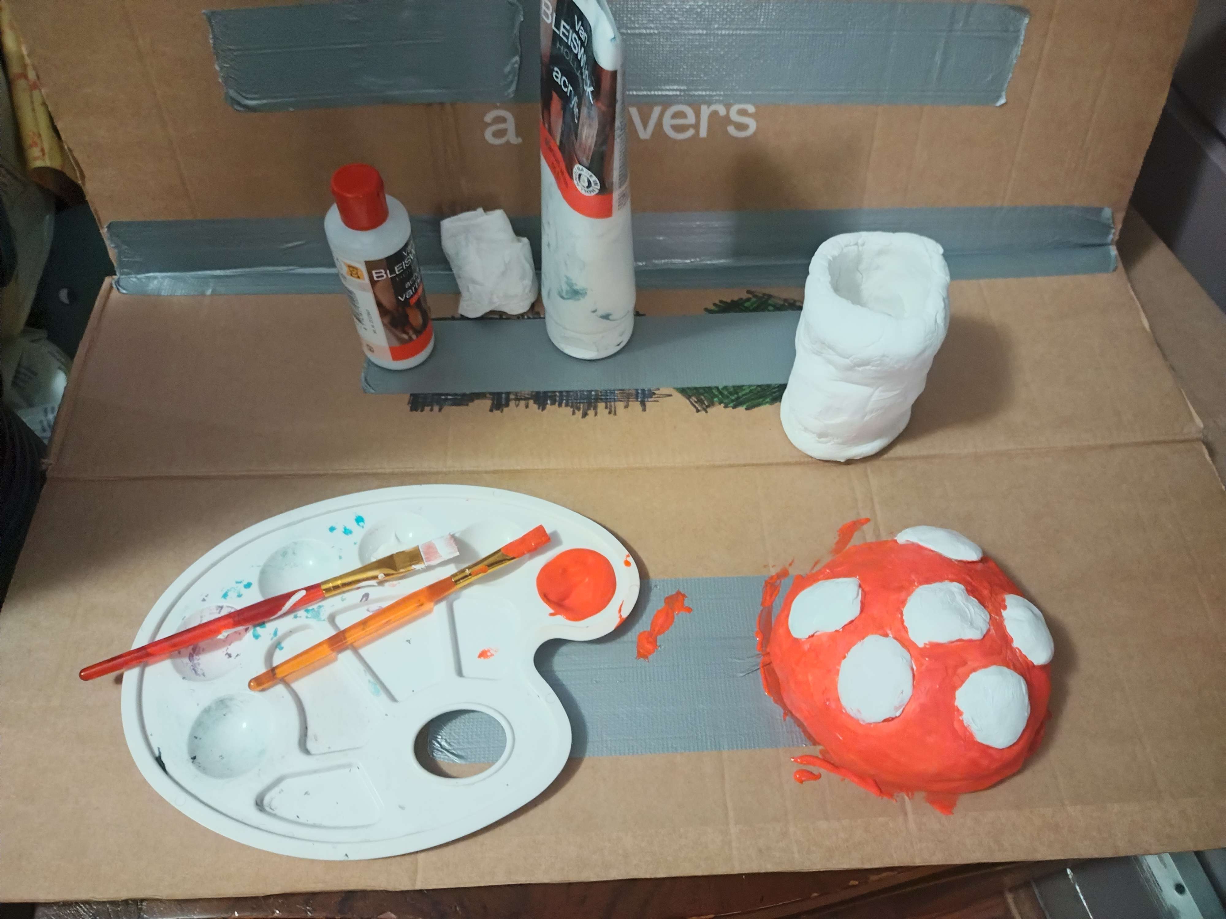 A picture of a painted sculpture and some painting supplies